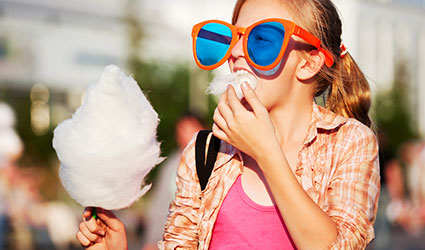 Child on vacation in Panama City Beach Florida enjoys Cotton Candy served at Mr. Puff's Hand-Rolled Ice Cream